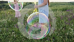 Large soap bubbles burst hitting the grass