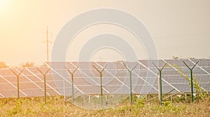 Large solar station with blue photovoltaic panels fenced with lattice and barbed wire. Producing clean energy from the