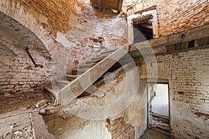 Large spacious forsaken empty basement room of ancient building or palace with cracked plastered brick walls, small windows, dirty