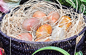 Large spotty eggs lying in basket filled with straw