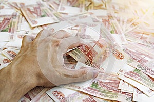 Large stack of banknotes, Russian rubles, banknotes 5000 rubles. hands are grabbing money. Lust for money