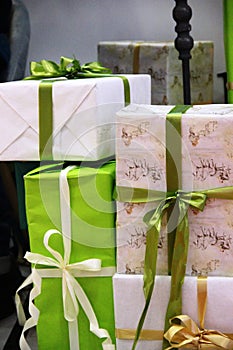 Large stack of Christmas presents. many of packaged boxes with gifts in green, beige and gold color tones. christmas