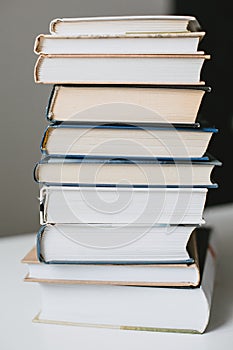 A large stack of different books on a table close-up