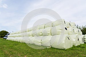 Large stack of hay bales wrapped in plastic. UK