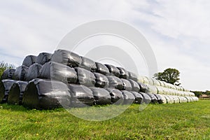 Large stack of hay bales wrapped in plastic. UK