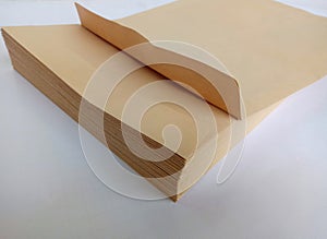 A large stack of plain brown envelopes with a white background