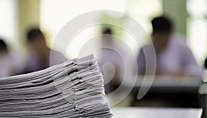 Large stack of white papers in a classroom setting