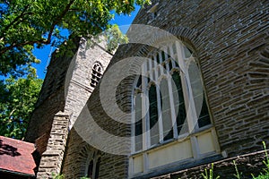 A Large Stained Glass Window on a Cobblestone Church