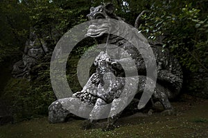 Large statue of the Dragon bitten by a lion and a dog at the famous Parco Dei Mostri in Italy photo