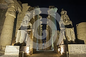 Statues and columns in hypostyle hall at Luxor Temple during night