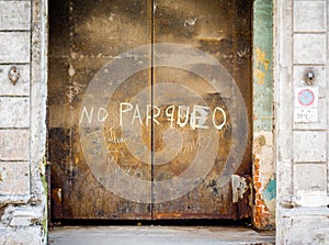 Large steel rusty doors in Havana, Cuba with no parqueo sign