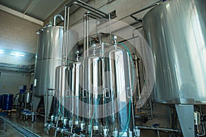 Large steel tanks or vats inside interior of juice and water production plant