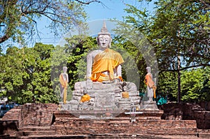 Large stone Buddha statue with orange sash, Ayutthaya, Thailand