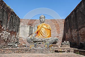 Large stone Buddha statue at the partially restored ruin of Wat Worachet Tharam in the ancient city of Ayutthaya, Thailand