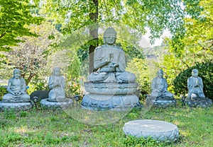 Large stone carved Buddha flanked by four smaller Buddhas