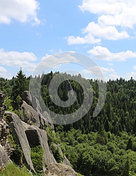 Large stone cliff in the forest. Ruins at the site of an ancient castle. Big boulders in the mountains.