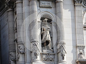 Large stone figure on the facade of the Museum building in the Louvre, Paris.