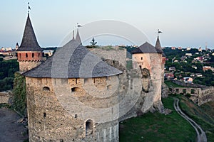 A large stone fortress with several towers in the background of the city. High angle view