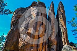 Large stone red rocks vertically layered with crevices in the light of sun. Big tall textured rough rock is called Feathers