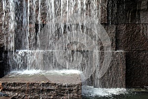 Large stone wall with water splashing from above