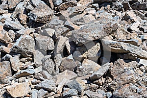 Large stones with sharp edges on the side of the mountain.