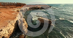 Large stones stick out of the water. Stone coast that washes the Mediterranean Sea.