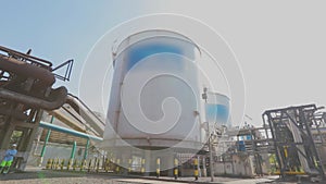 Large storage tanks in the factory. Exterior of a modern factory. White storage tanks for liquids in a modern factory