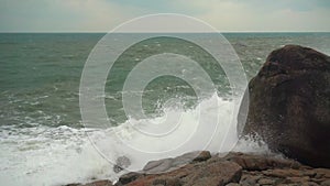 Large storm waves crashing on rocks in slow motion