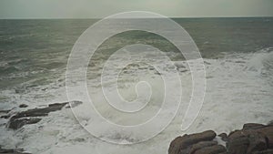 Large storm waves crashing on rocks in slow motion