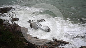 Large storm waves crashing on rocks in slow motion