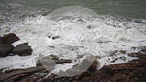 Large storm waves crashing on rocks in slow motion