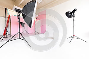 Large studio space white cyclorama and natural light from large windows. lighting equipment and flash