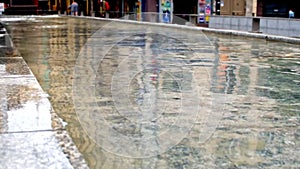 A large surface of water in an urban fountain in the center of the city of Perpignan, France.