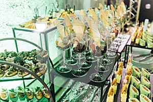 Large table with snacks of different types at a party with creative disco lighting.