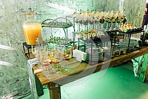 Large table with snacks of different types at a party with creative disco lighting.