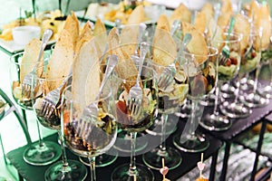 Large table with snacks of different types at a party with creative disco lighting.