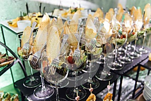 Large table with snacks of different types at a party with creative disco lighting.