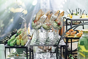 Large table with snacks of different types at a party with creative disco lighting.