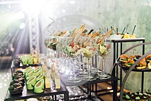Large table with snacks of different types at a party with creative disco lighting.