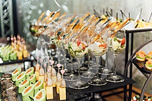 Large table with snacks of different types at a party with creative disco lighting.