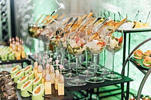 Large table with snacks of different types at a party with creative disco lighting.