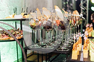 Large table with snacks of different types at a party with creative disco lighting.