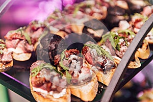 Large table with snacks of different types at a party with creative disco lighting.