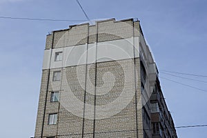 Large tall house with gray brick wall windows and balconies