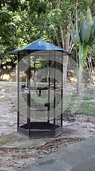 Large and tall outdoor iron bird cage in the middle at the park