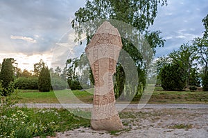 Large and tall rune stone with runes in the shape of a long red snake