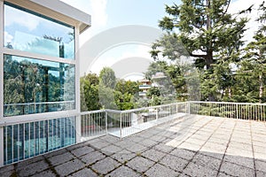 Large terrace in country house with big trees view and glass elevator