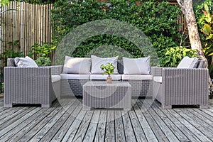 Large terrace patio with rattan garden furniture in the garden on wooden floor.