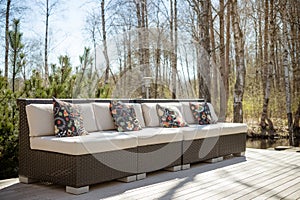 Large terrace patio with rattan garden furniture set.Wooden garden lounge chair with cushion. comfortable rattan sofa. relaxing photo