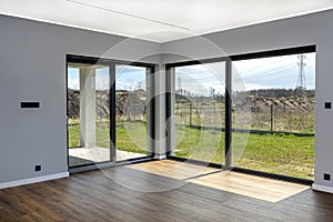 Large terrace windows overlooking the garden, the view from inside the living room on the floor are vinyl panels.